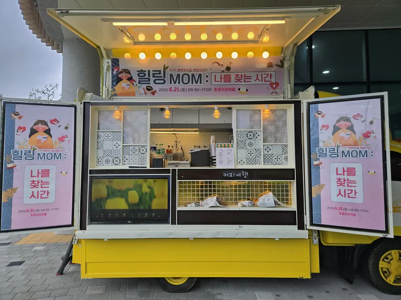행사 현수막과 포스터로 꾸민 노란 트럭 정면