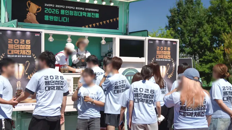 행사 단체티를 입은 대학생들이 민트색 트럭 앞에 모여 음료를 받는 모습